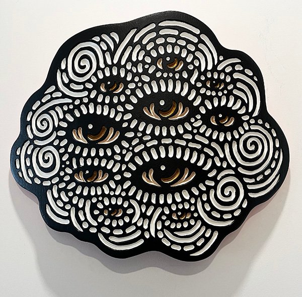 wood carving of a fluffy cloud full of watchful eyes by Canadian artist Lisa Brawn