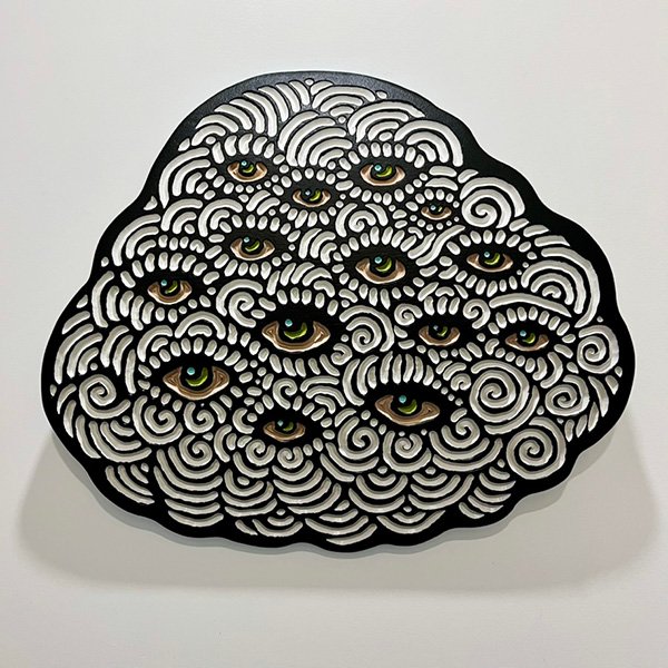Wood carving of a fluffy cloud full of watchful eyes by Canadian artist Lisa Brawn