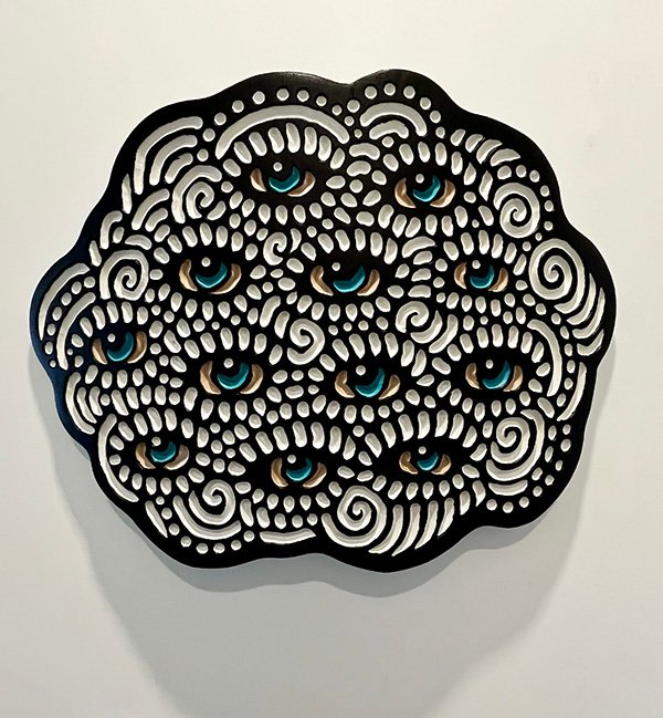 Wood carving of a fluffy cloud full of watchful eyes by Canadian artist Lisa Brawn