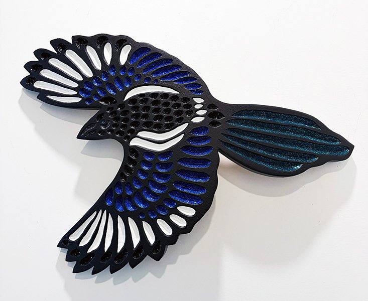 magpie in flight carved on curved wood by Canadian artist Lisa Brawn