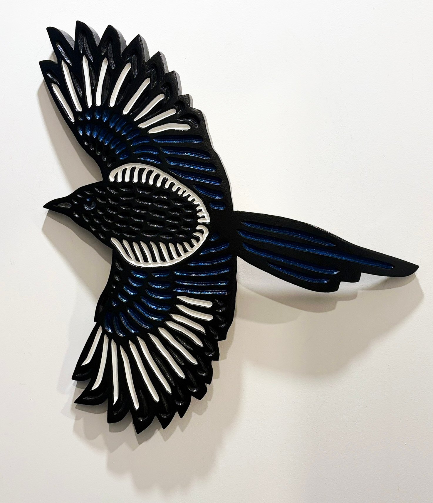 wood carving on curved oak of a Magpie bird in flight by Canadian artist Lisa Brawn